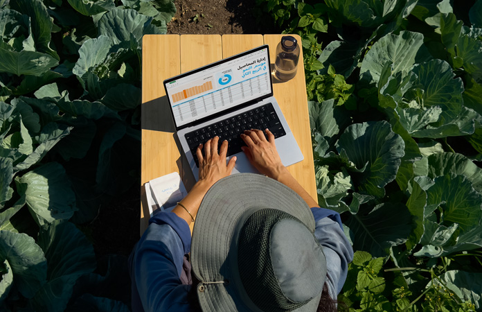 شخص في الخارج يستخدم MacBook Pro مع خيار الشاشة المعالجة بتكنولوجيا النانو لتوضيح انخفاض الوهج