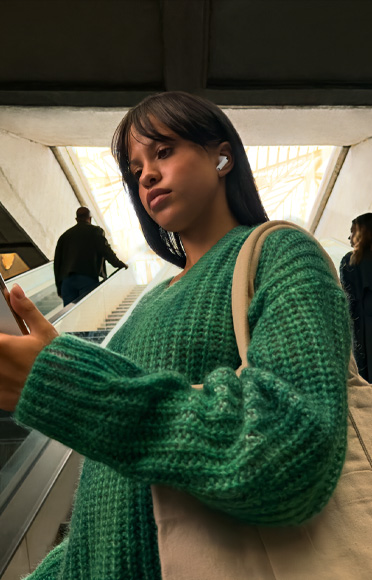 Людина в навушниках AirPods Pro 3 дивиться у свій iPhone