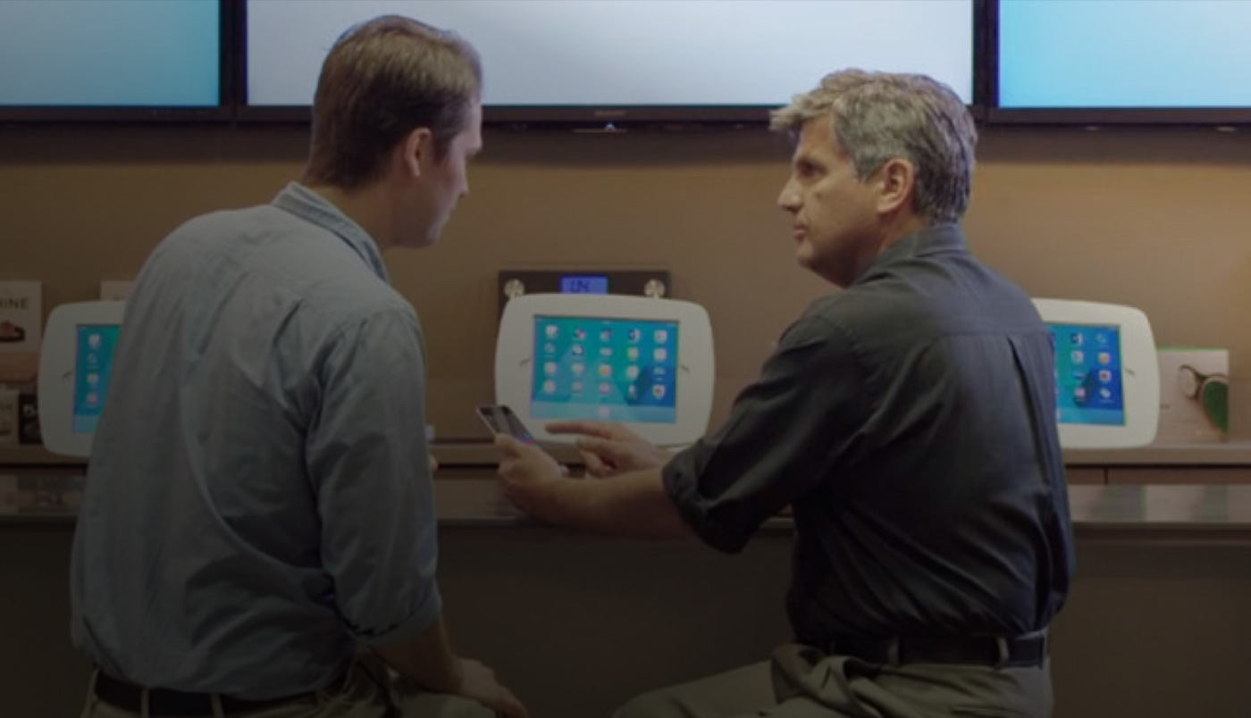 兩位男士坐在 O Bar，看著 iPhone 螢幕。