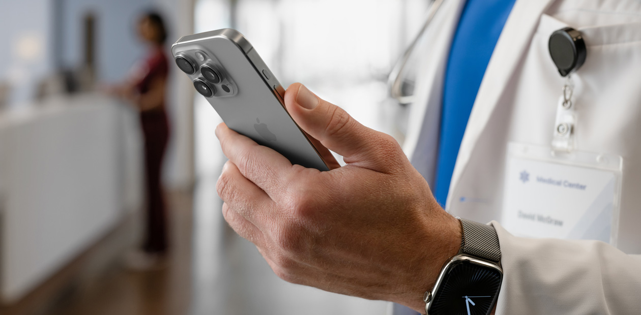 صورة لطبيب يحمل في يده جهاز iPhone.‏