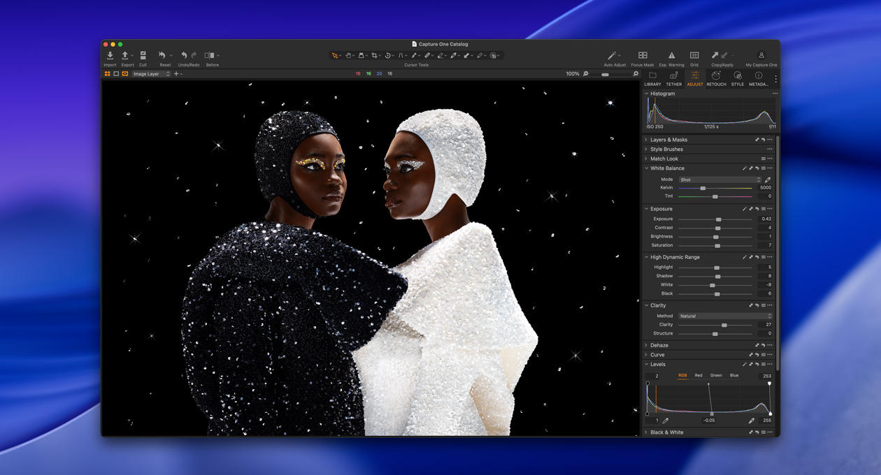 سيدة ترتدي ملابس سوداء وتقف جانبياً قرب سيدة ترتدي ملابس بيضاء، لتوضيح السطوع والتباين المتوفرين مع شاشة Studio Display XDR